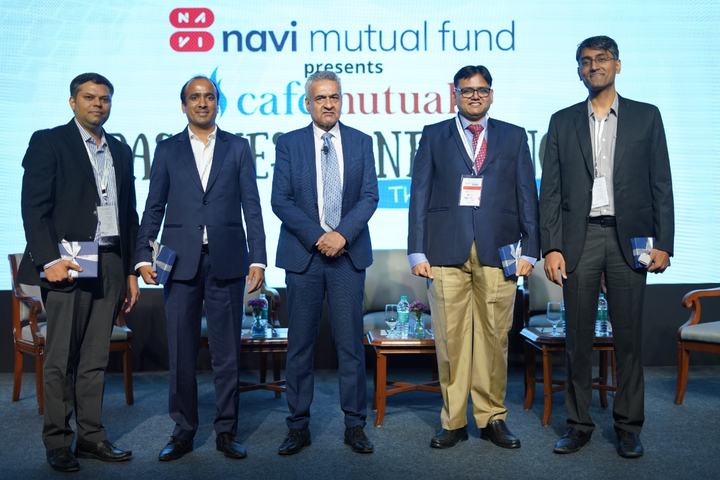 Six speakers stand on stage in front of a ‘navi mutual fund presents cafemutual’ backdrop.