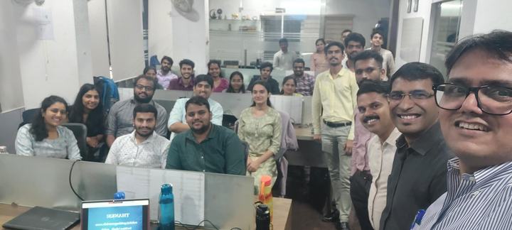 A large group of colleagues seated together in an office for the year-end review.