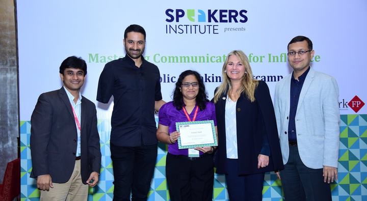 Rohit Shah and four others on stage in front of a Speakers Institute backdrop; one holds a certificate.