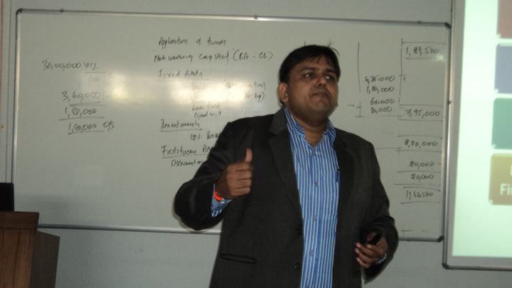 Rohit Shah speaking in front of a whiteboard covered with notes.