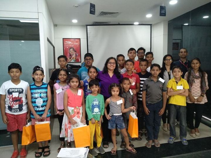 A group of children holding gift bags, with adults standing behind them.