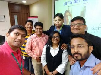 A group selfie of participants in front of a screen.